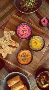 hummus, beetroot and capsicum dips with turkish bread on paddle board